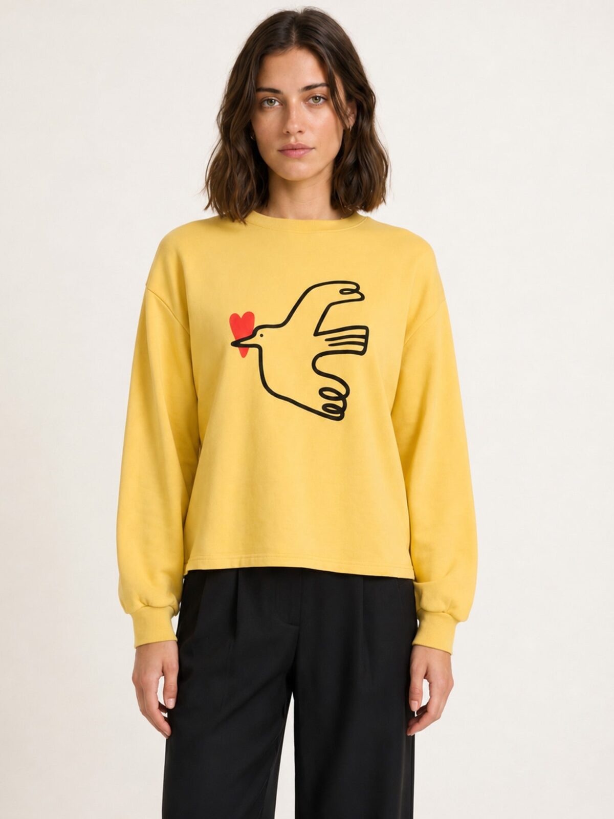 Top de punto amarillo avellana con ilustración de pájaro y corazón rojo de Pepaloves en Tiendas Via Vai Estepona