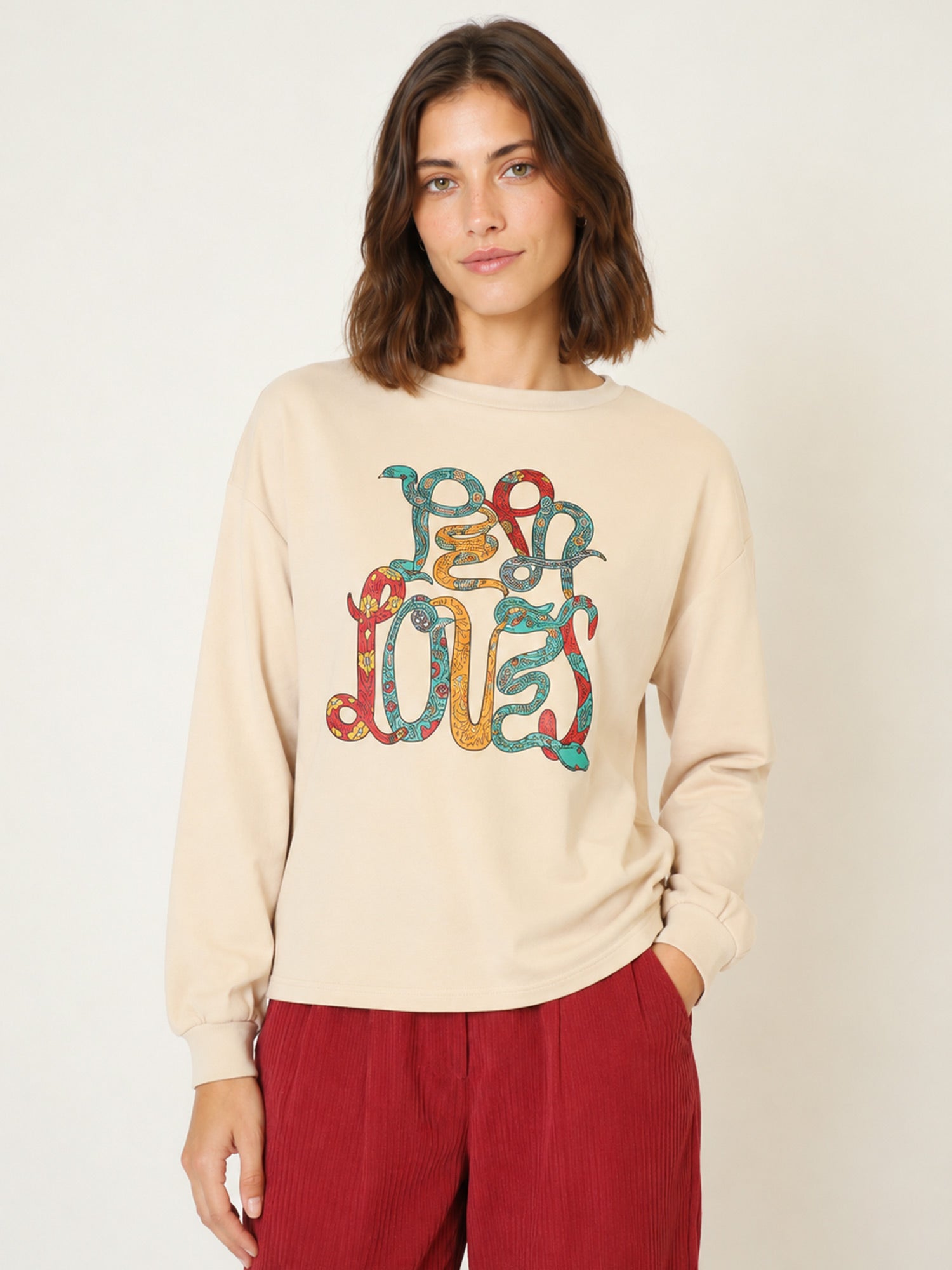 Camiseta beige con el nombre Pepaloves y serpientes psicodélicas de colores en Tiendas Via Vai Estepona