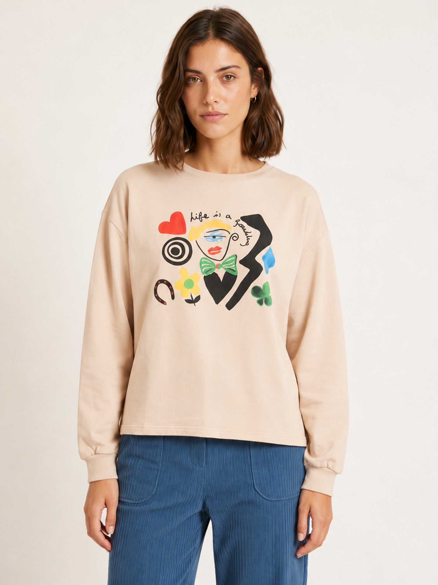 Camiseta de punto beige con diseño artístico central y corazón rojo de Pepaloves en Tiendas Via Vai Estepona