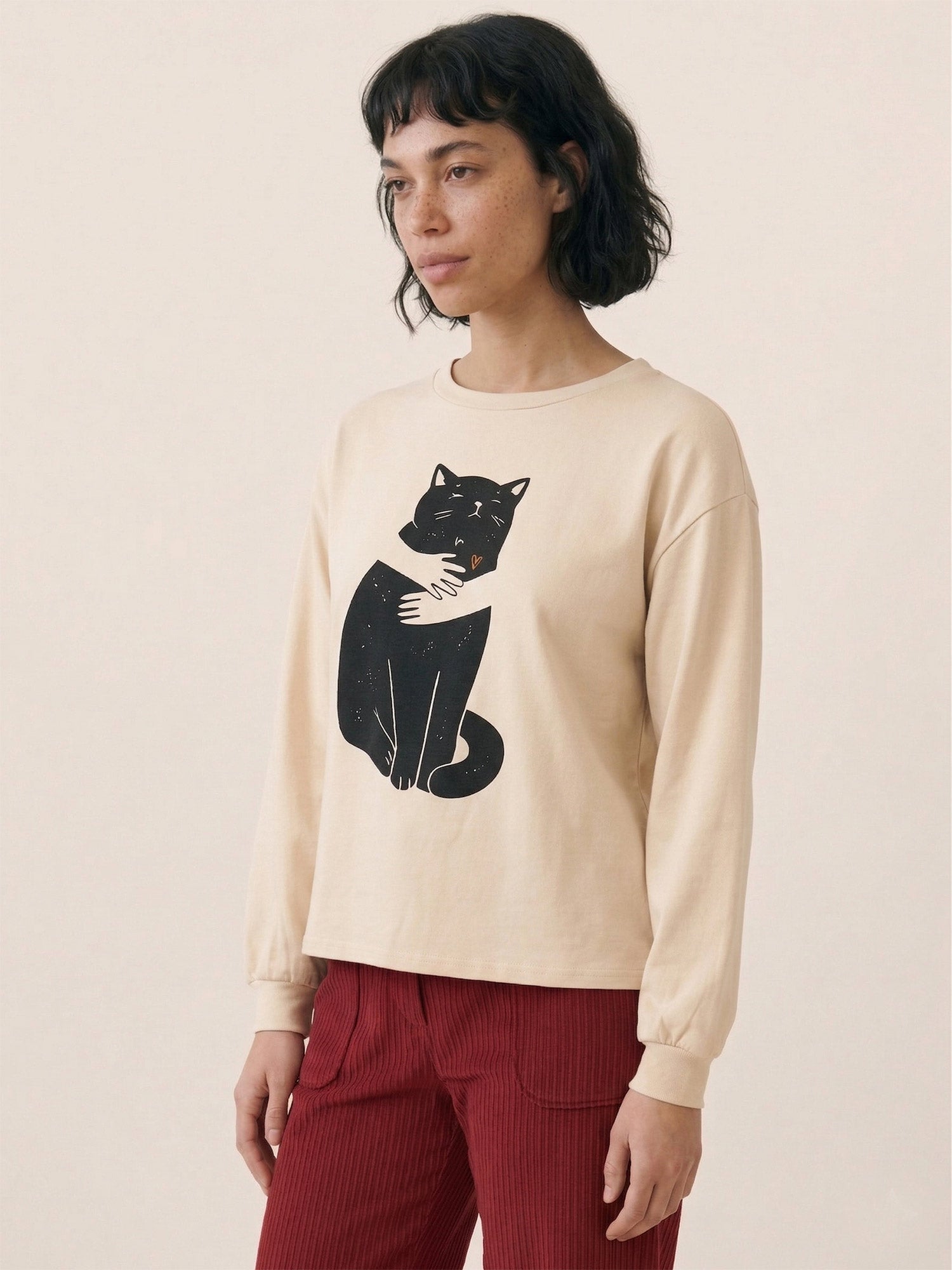 Camiseta beige con ilustración de un gato negro y corazón naranja de Pepaloves en Tiendas Via Vai Estepona (foto 2)