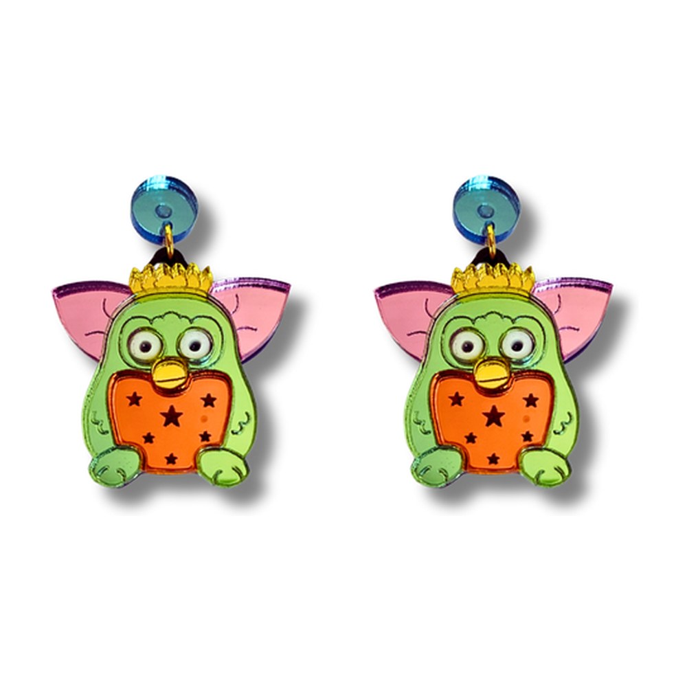Pendientes de metacrilato con un Furby verde de orejas rosas, corona dorada y barriga naranja con estrellas, fondo blanco