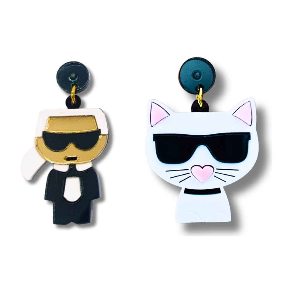 Pendientes de metacrilato con un diseñador de pelo blanco, gafas y traje negro y una gata blanca con gafas